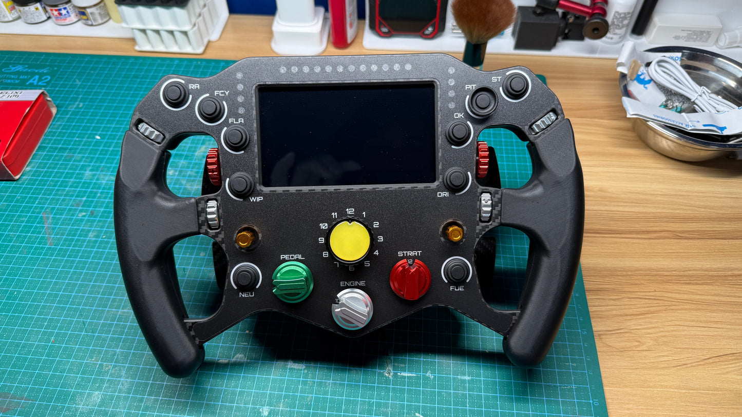 Ferrari 499P endurance sim racing wheel front view with central telemetry display and colored rotary dials, green clutch and red start buttons, Moza Simagic compatible.