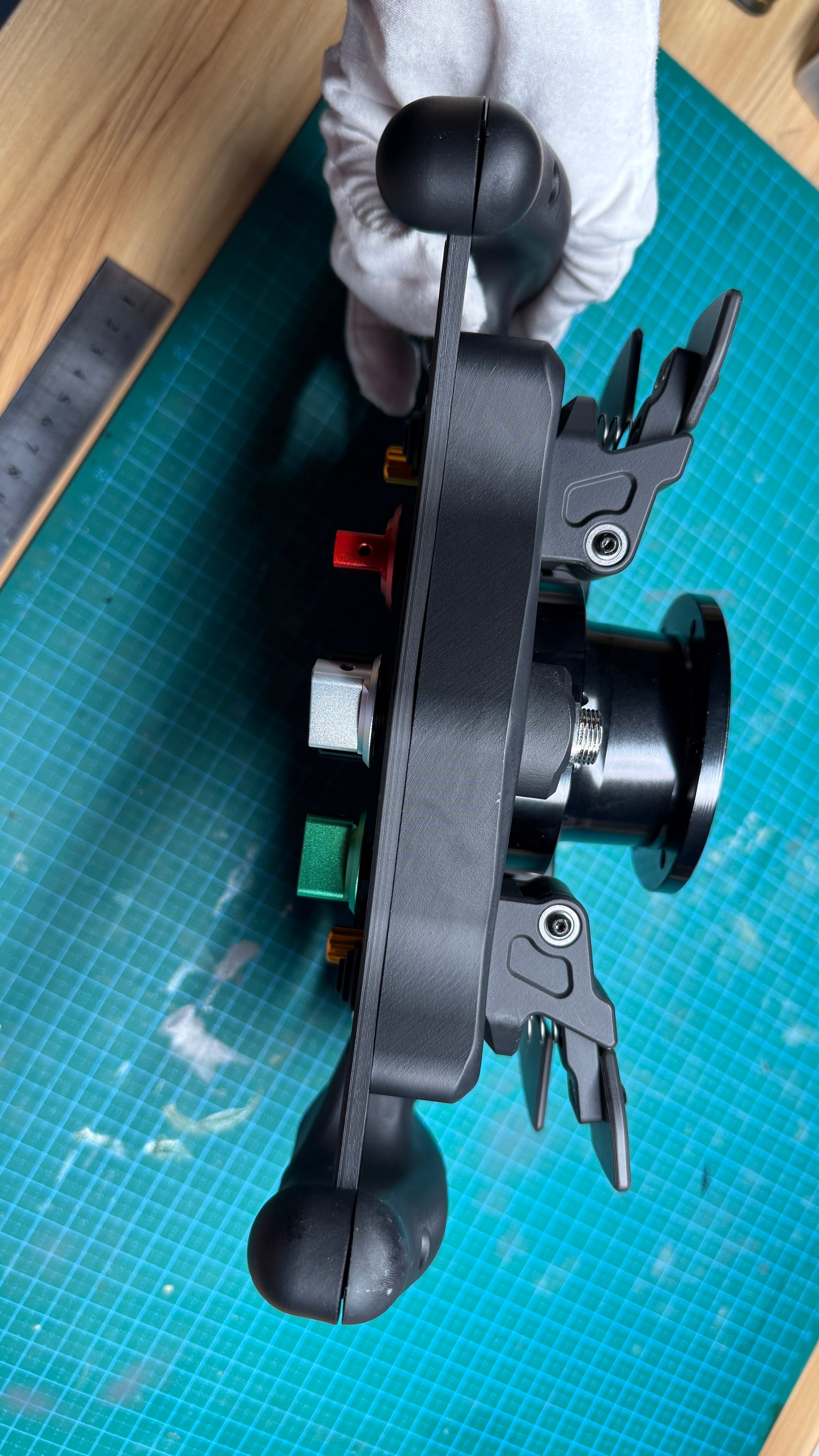 Ferrari 499P endurance sim racing wheel rear paddle view with twin magnetic shifter paddles and central clutch paddle behind the molded hand grips.