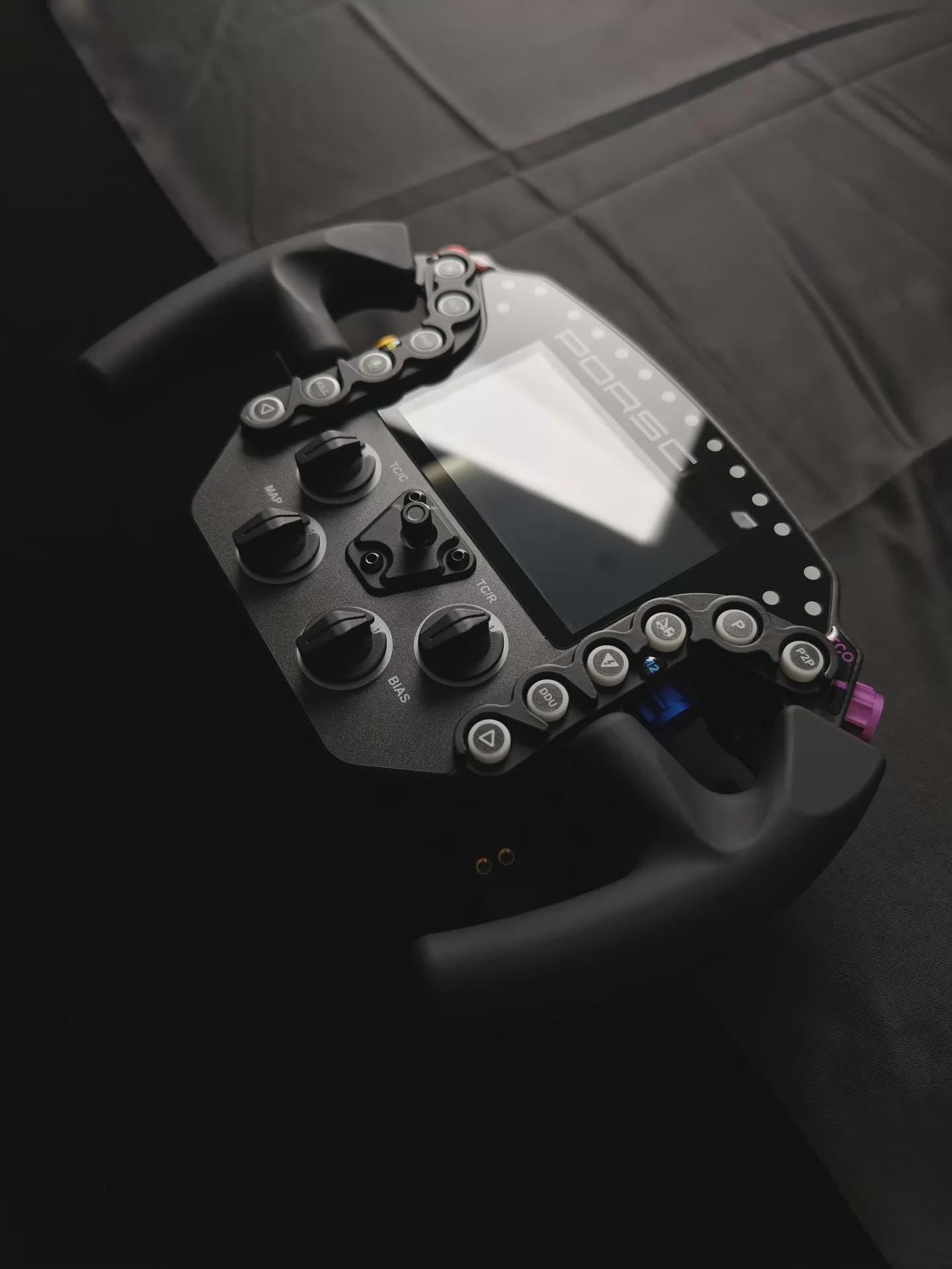 911 GTE Pro sim racing wheel close-up of ergonomic silicone grips and thumb dials