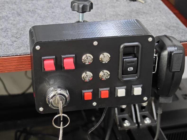 ETS2 button box controller mounted with desk clamp next to handheld mic, ready for Euro Truck Simulator 2 and American Truck Simulator cockpit setup